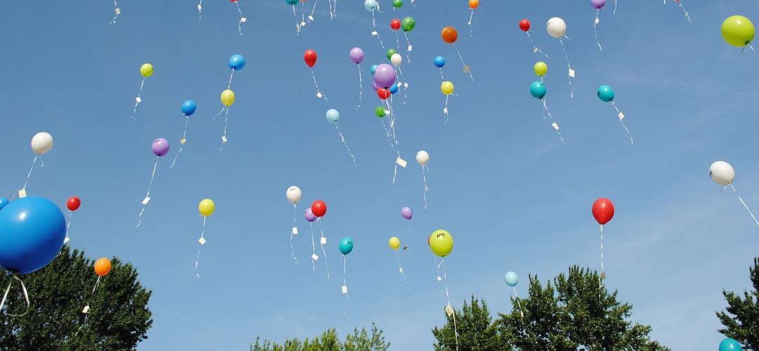 Viele Luftballons steigen in den Himmel auf