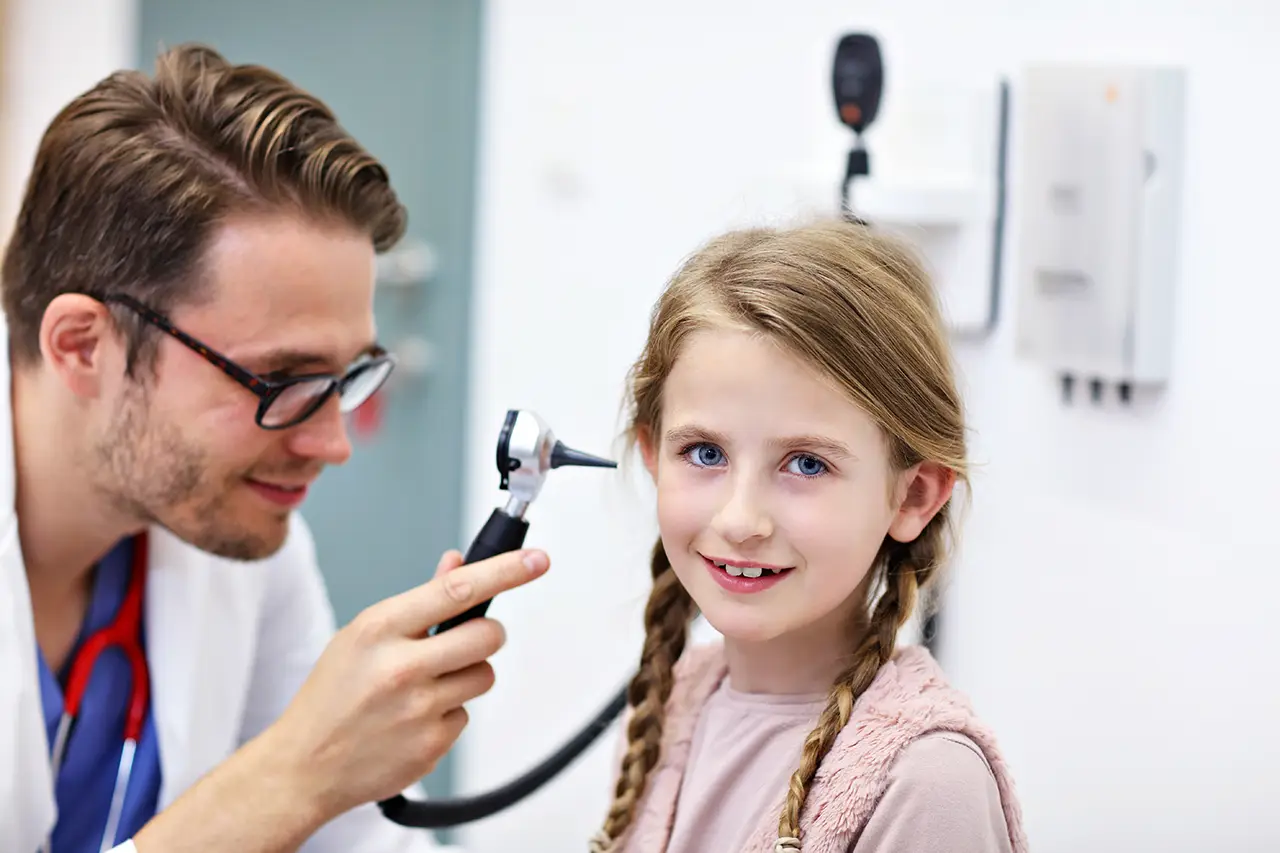 HNO Arzt untersucht ein Mädchen am Ohr